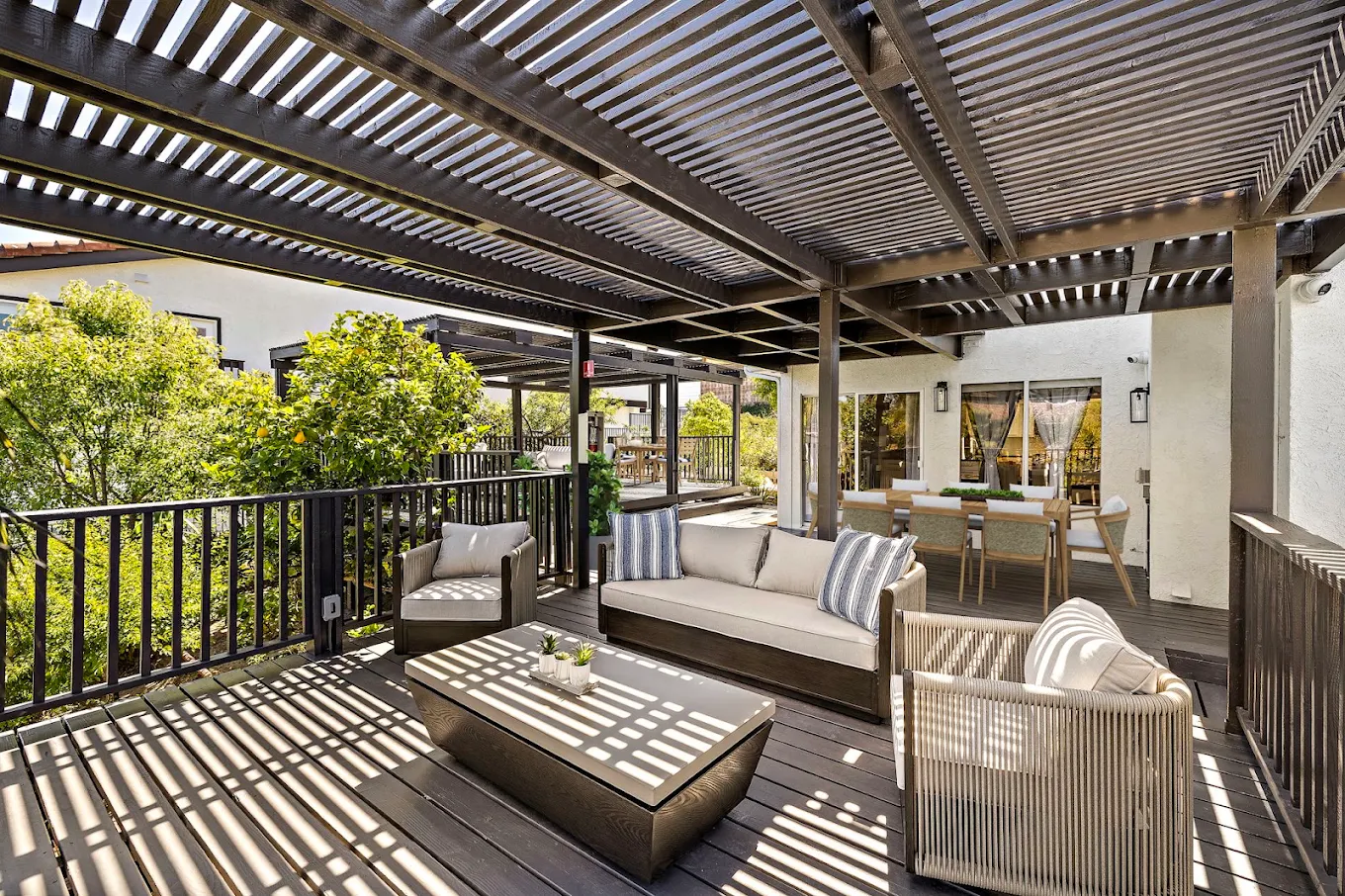 Covered patio with sofa, chairs, and outdoor dining area