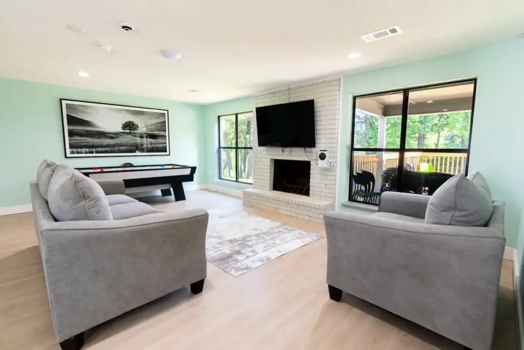 Cozy lounge with fireplace, TV, and game table.