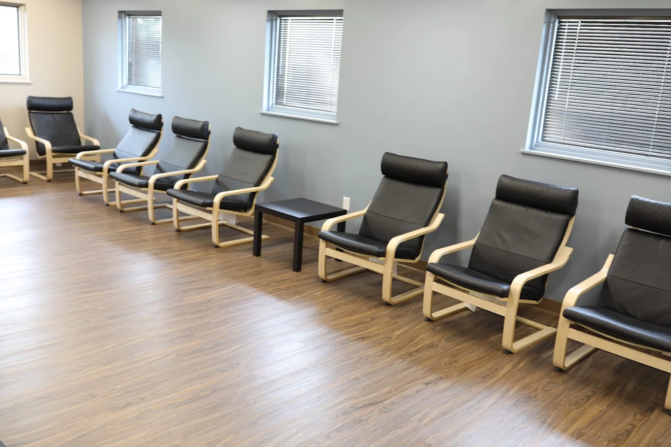 Treatment room with black chairs along the walls