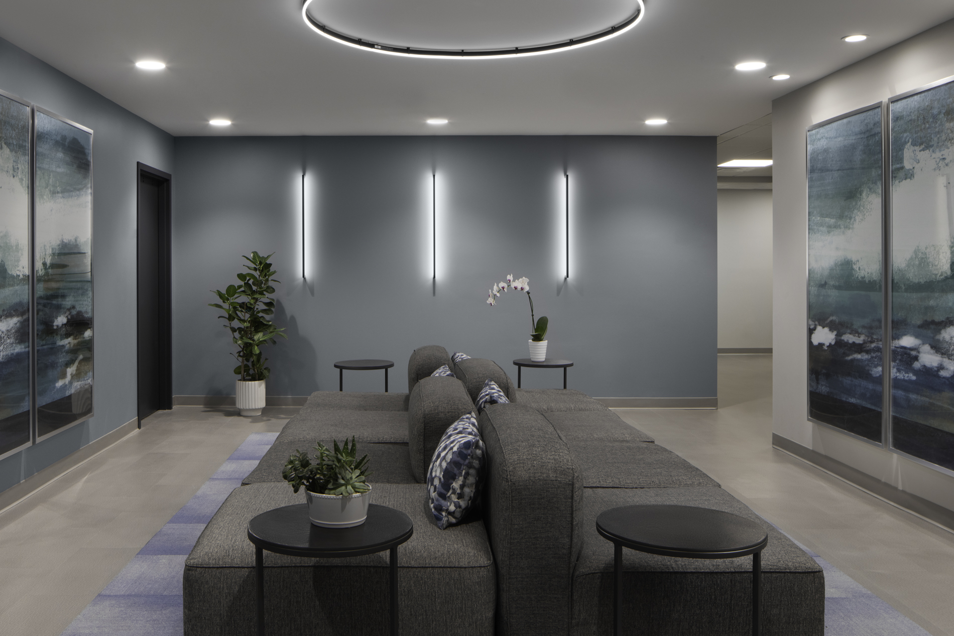 Gray sectional sofa and wall art in a waiting area