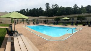 Pool with lounge chairs and green umbrellas