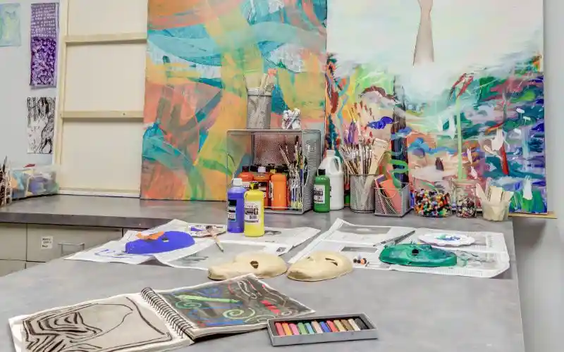 Art therapy room with paints, masks, and colorful artwork