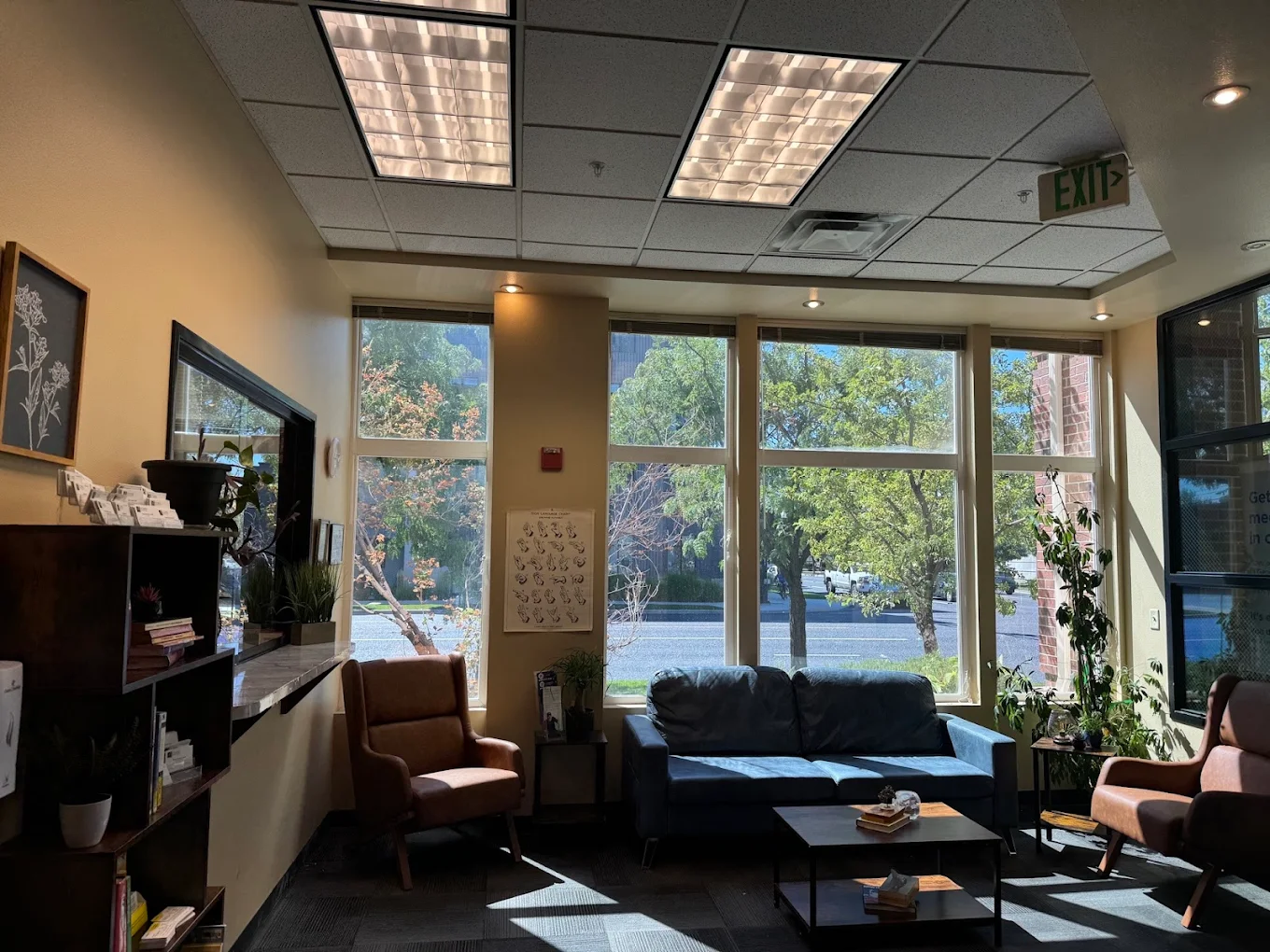 Bright waiting area with sofa, chairs, and large front windows