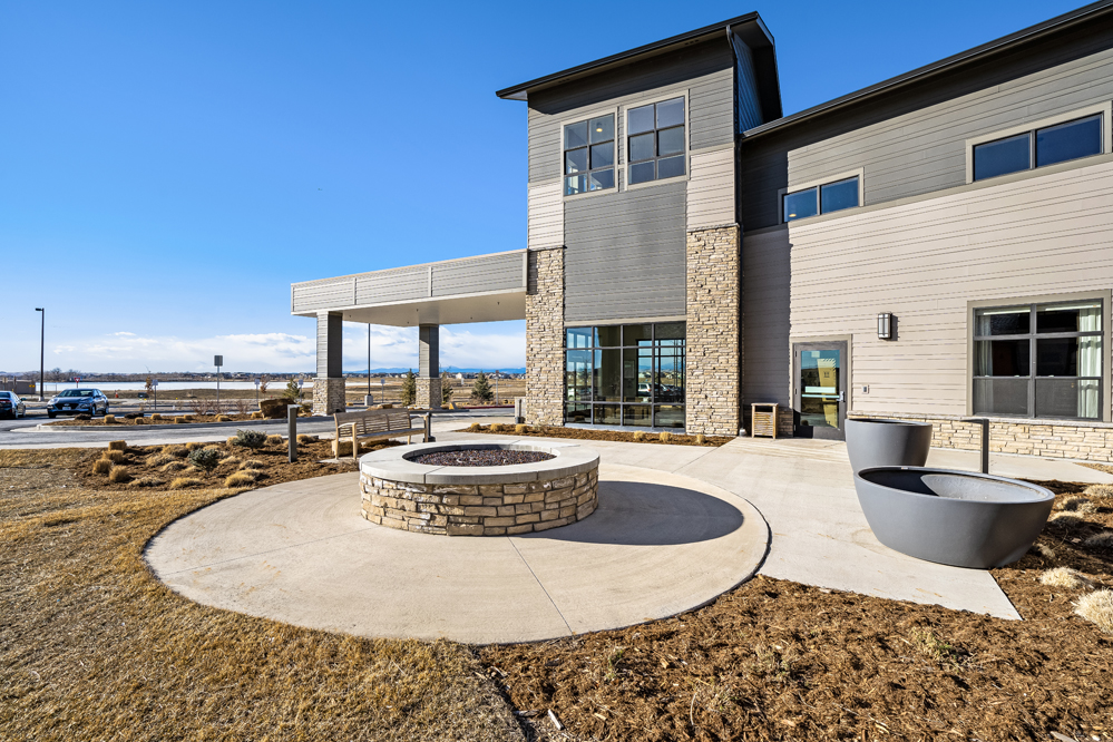 Outdoor fire pit and seating near facility entrance