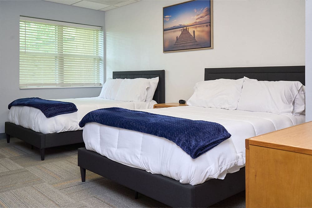 Double-bed patient room with soft lighting and decor