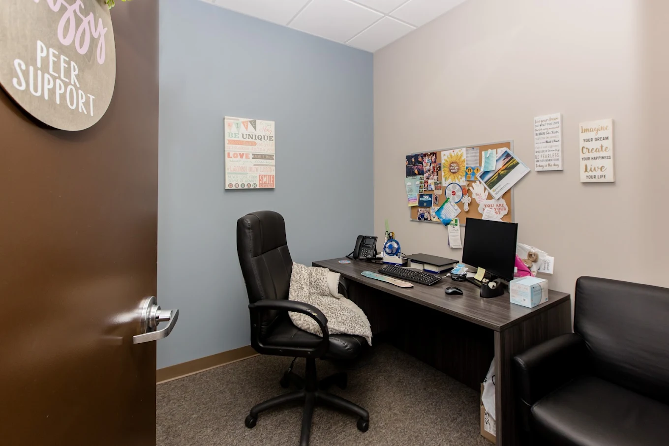 Private consultation office with desk, computer workstation, office chair, and guest seating