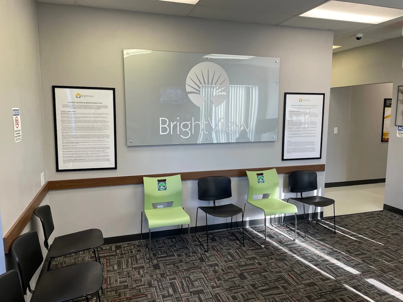 Waiting area with seating beneath a large BrightView wall sign