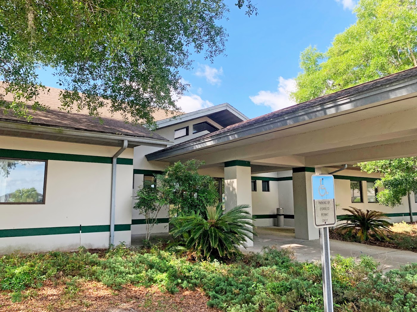 Facility entrance with covered walkway and lush greenery