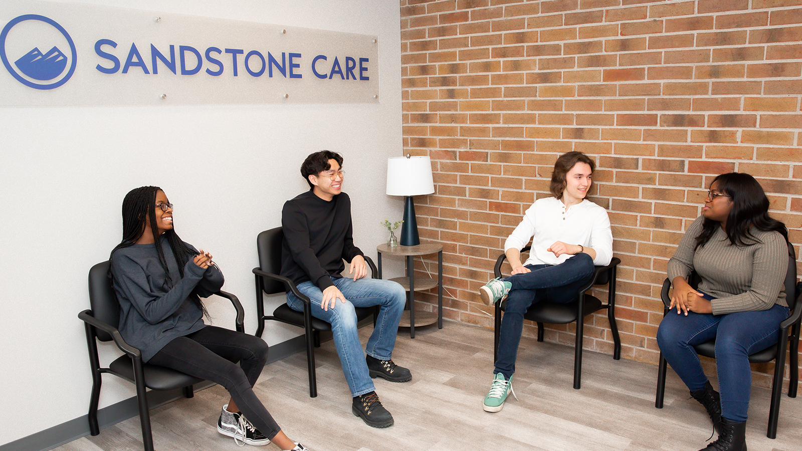 Interior waiting room with row of chairs against a wall.