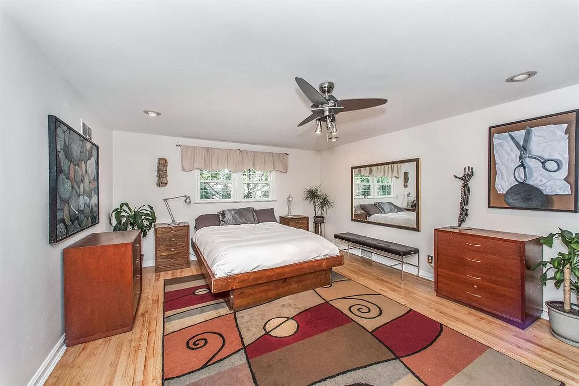 Private bedroom with bed, side-tables, and large mirror.