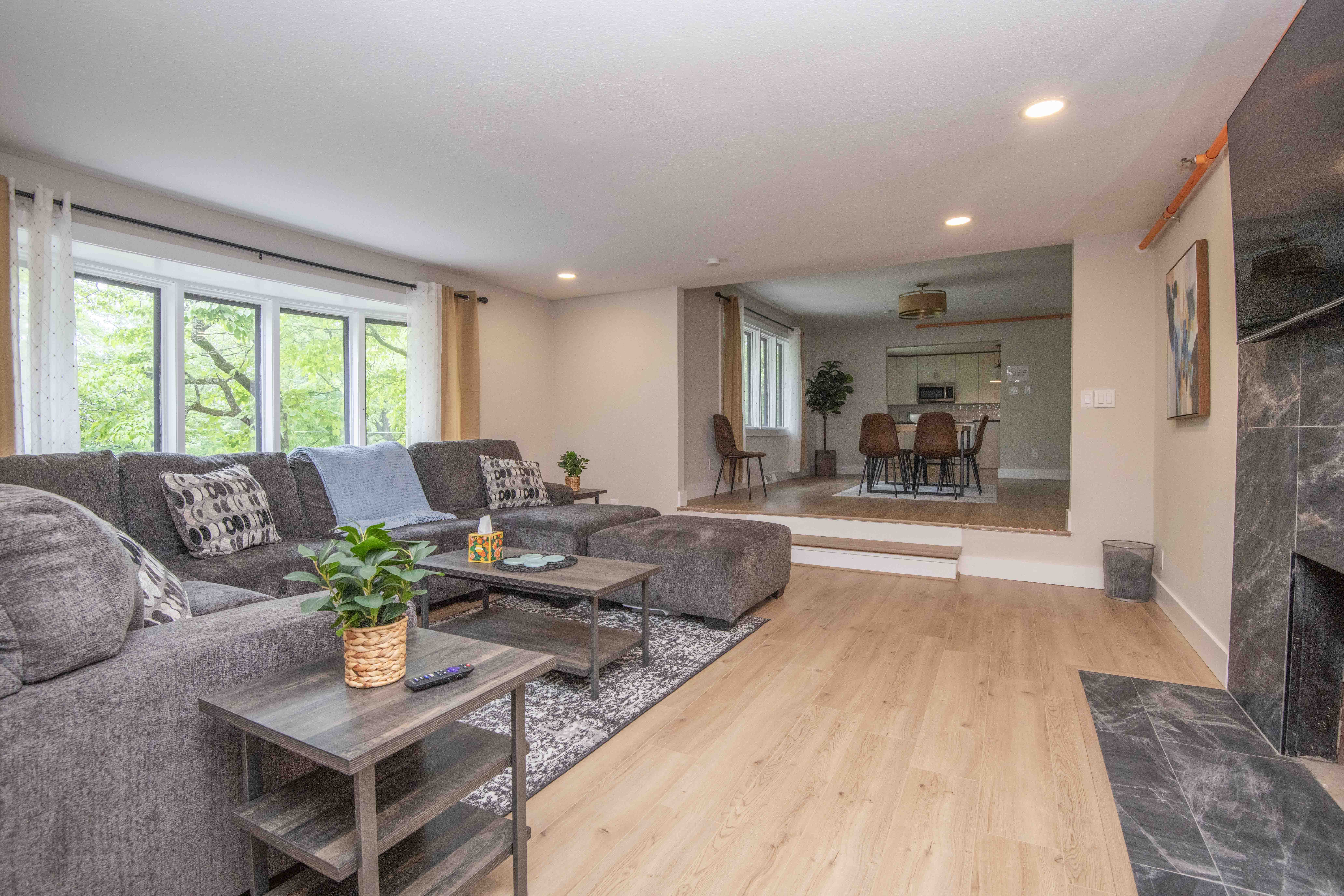 Spacious living room with gray sectional and large window
