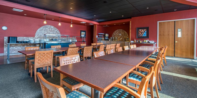 A bright, welcoming dining area with warm lighting, modern decor, and ample seating, offering a comfortable space for meals and gatherings.