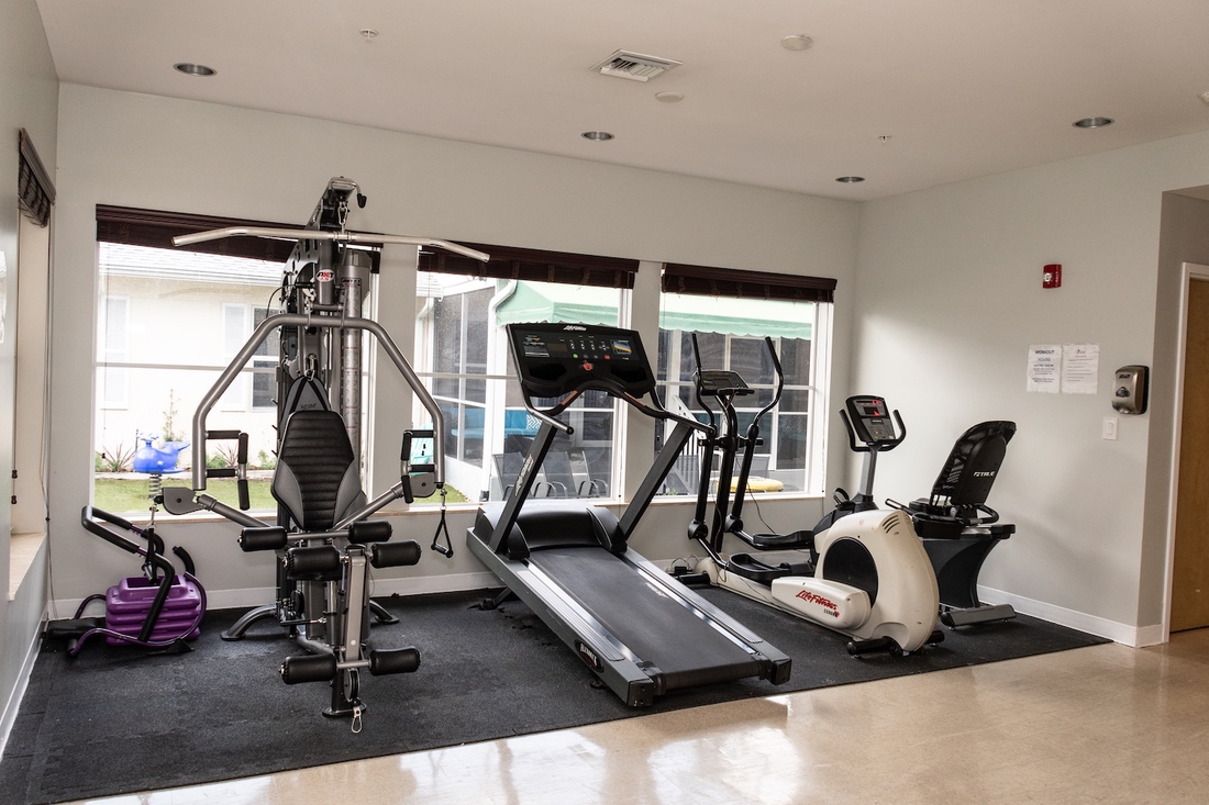 Gym with treadmill, weight machine, and exercise bikes