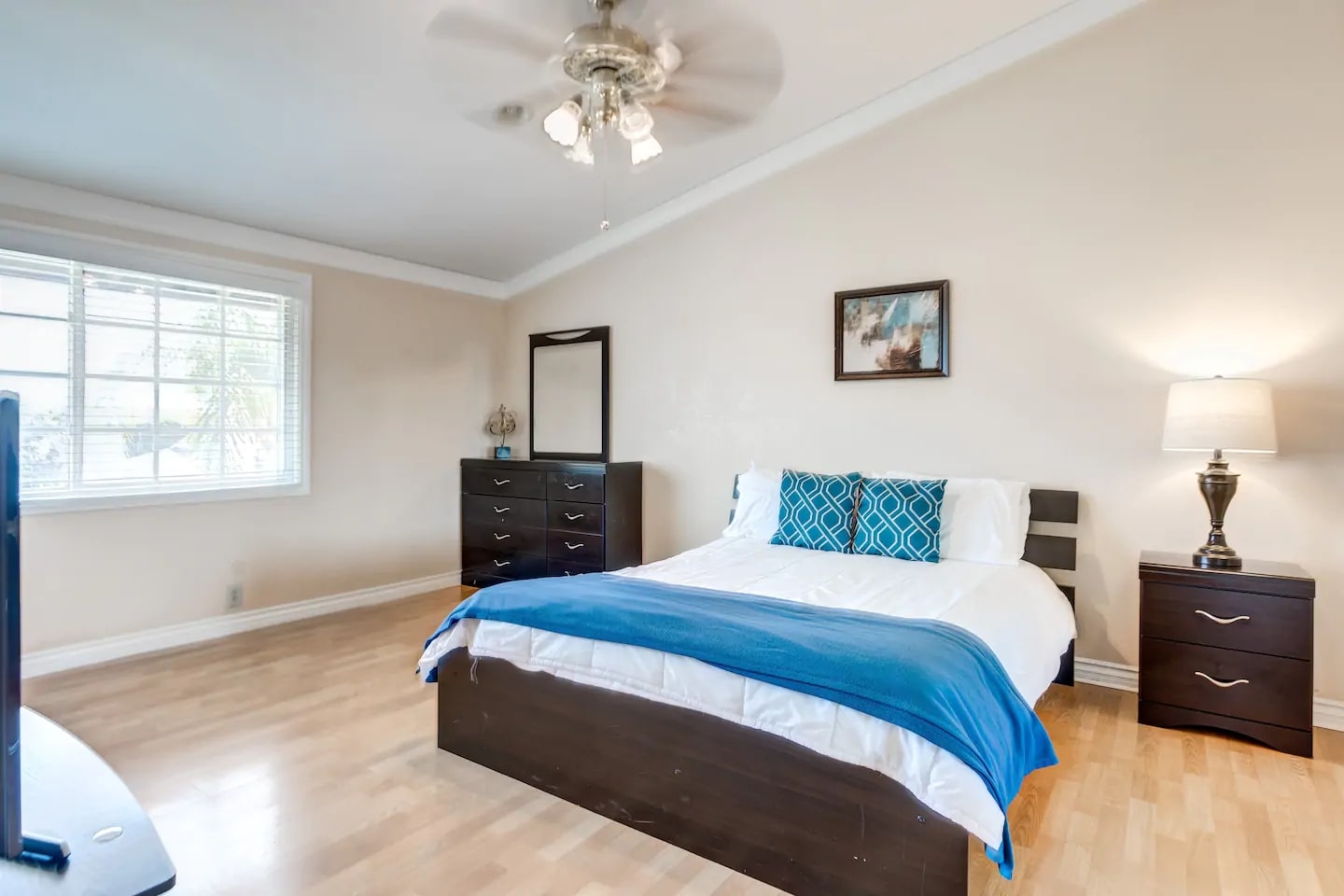Bright bedroom with queen bed, blue accents, and modern decor