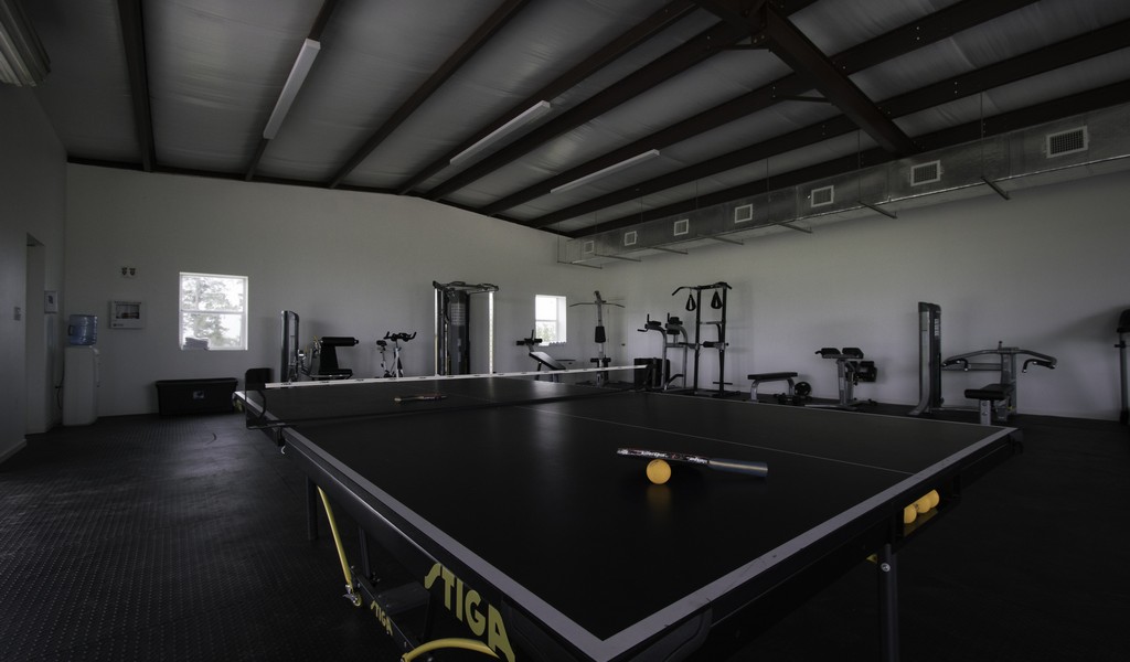 Gym with a ping pong table and equipment.