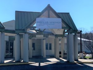 Covered hospital entrance with white columns and sign