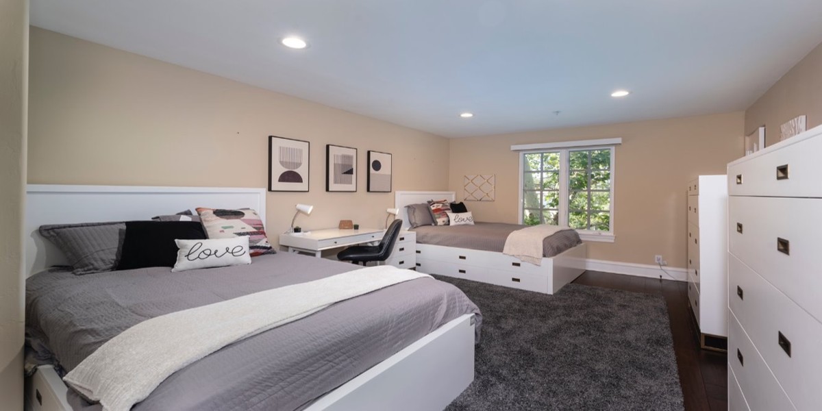 Shared bedroom with two beds, desk, and natural light