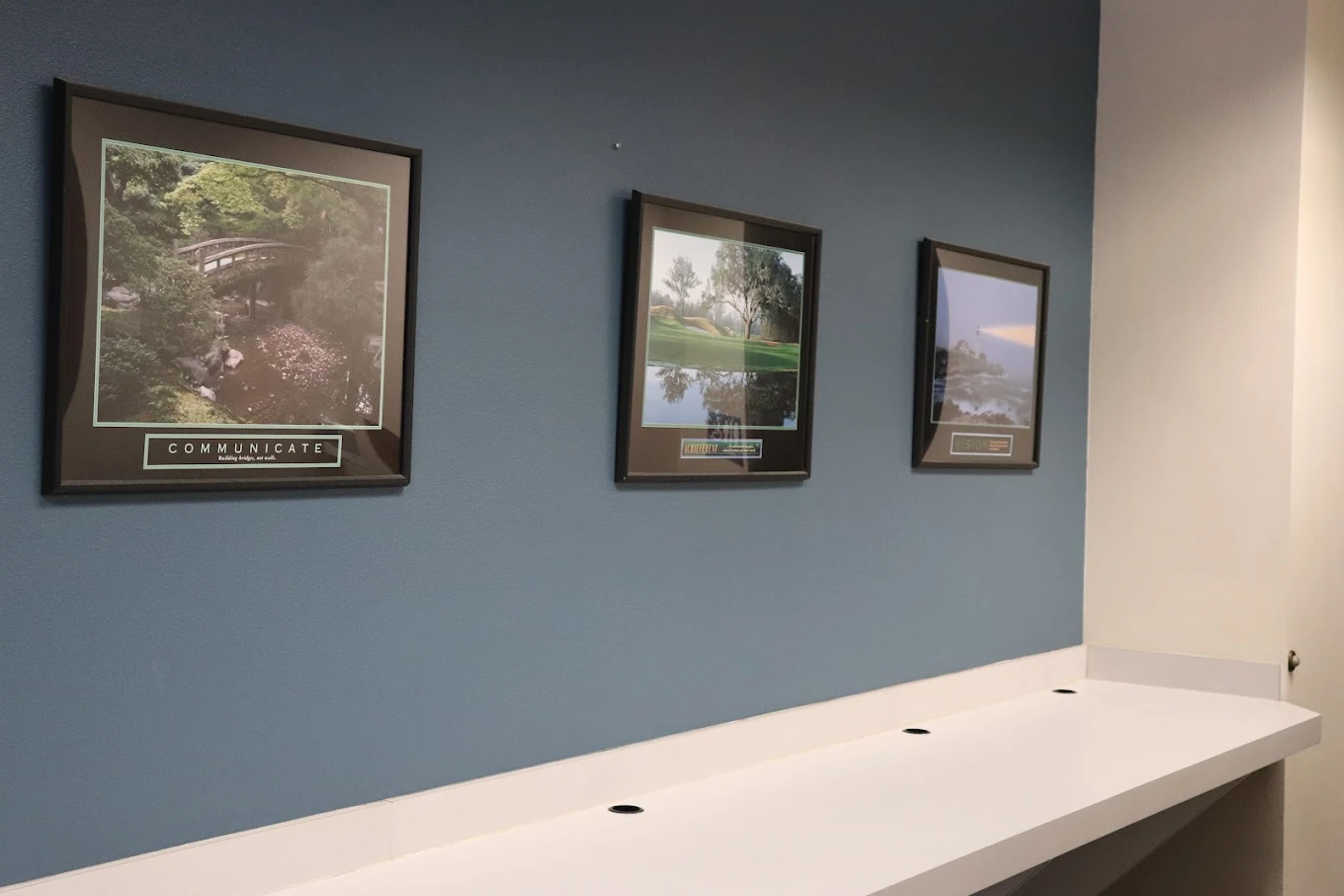 Framed landscape prints on blue wall above counter