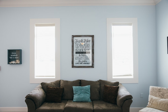 Couch with teal pillow and wall quotes