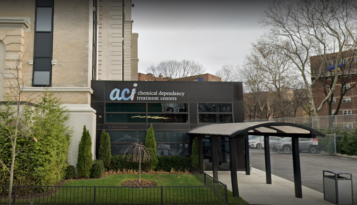 Etrance to a treatment center with green landscaping.